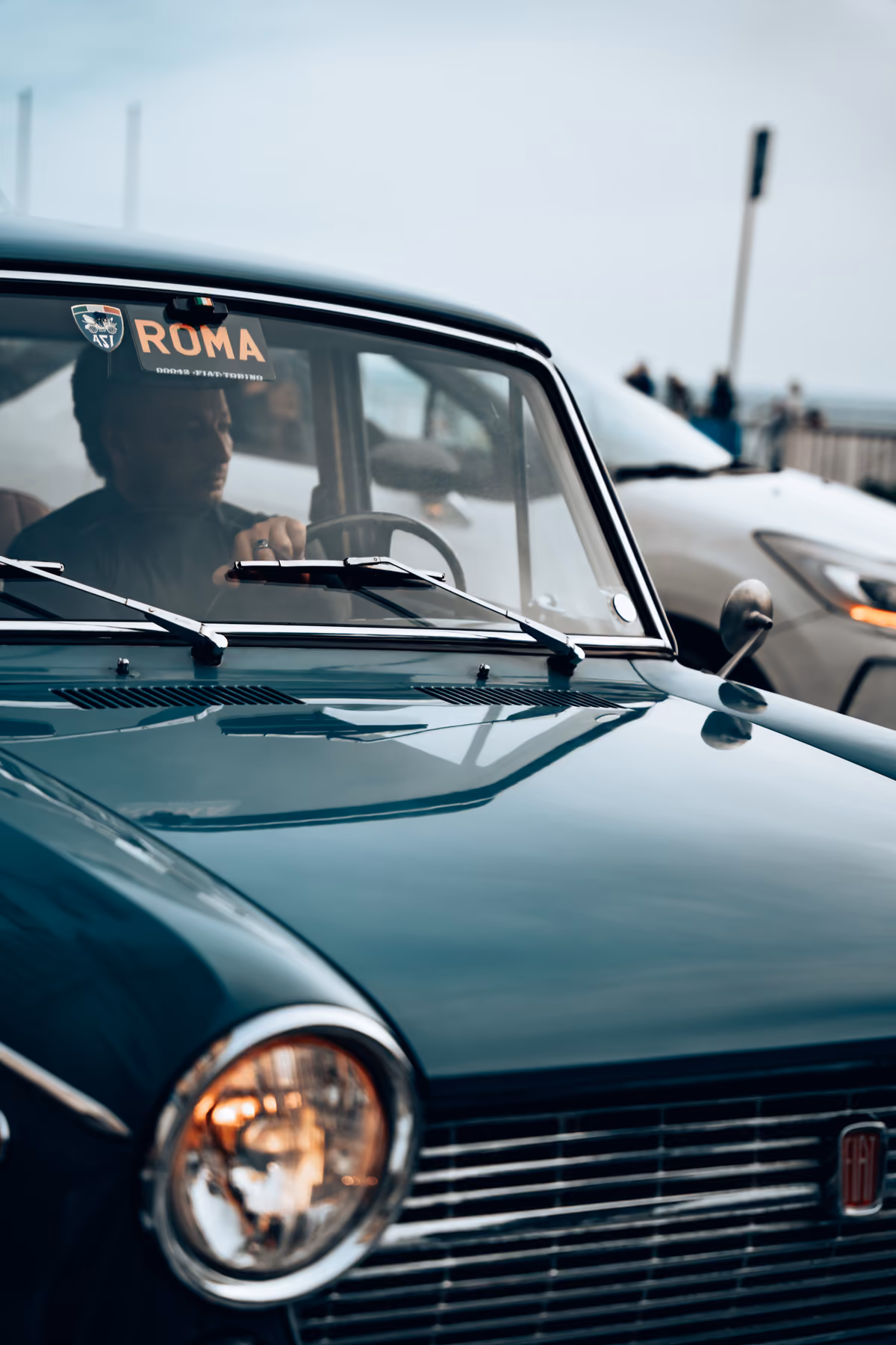 Dark green vintage Fiat with a Roma windshield sticker