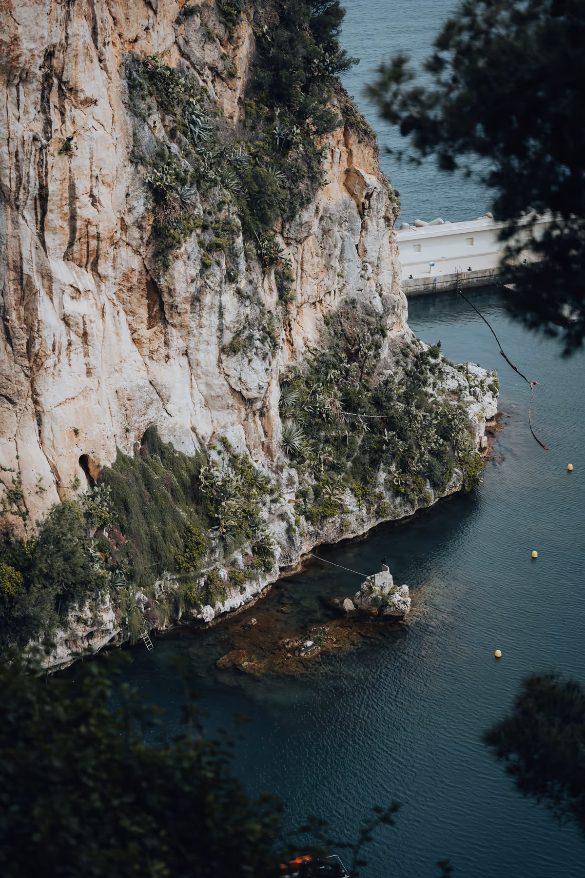 Rocky cliff face meeting turquoise water